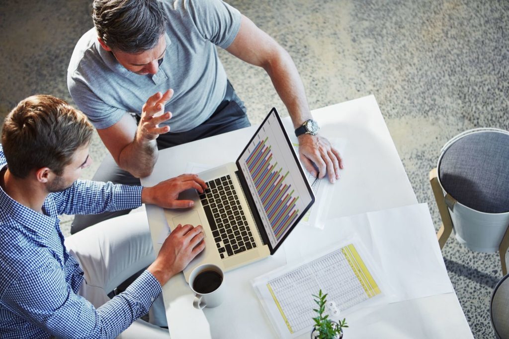 Two Guys Reviewing financial reporting on laptop hero image